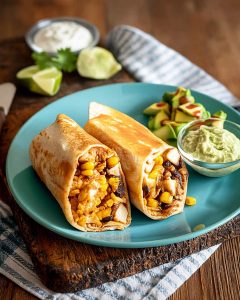 Chicken burrito meal prep wraps filled with seasoned chicken, black beans, and corn.