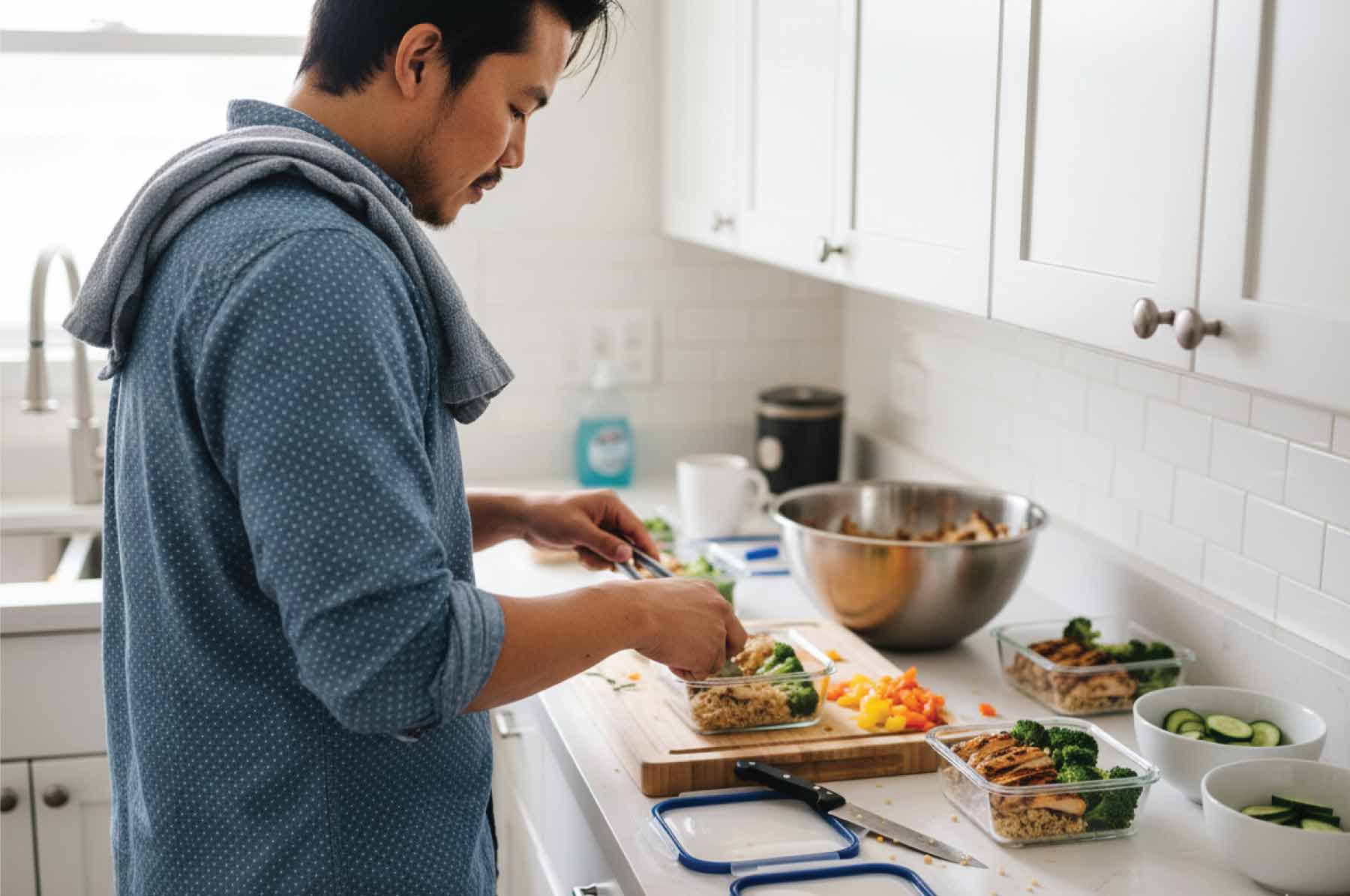 Marcus Santos preparing meal prep containers during Sunday batch cooking session