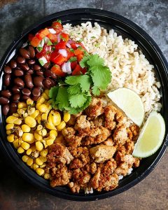 Burrito bowl with seasoned chicken, cilantro lime rice, black beans, roasted corn, pico de gallo.