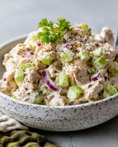 Meal prep chicken salad with tender chicken, celery, red onion, creamy dressing, and black pepper.