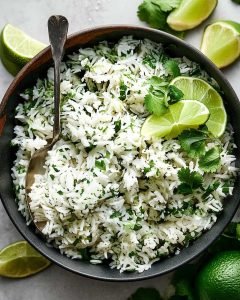 Cilantro lime rice meal prep with fluffy white rice, fresh cilantro, bright lime wedges, and zesty citrus flavor.