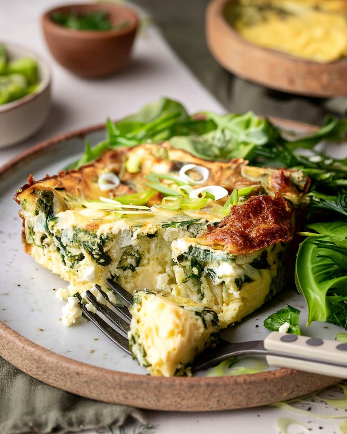 Cottage Cheese Egg Bake slice with fluffy eggs, creamy cottage cheese, and spinach, topped with green onions.