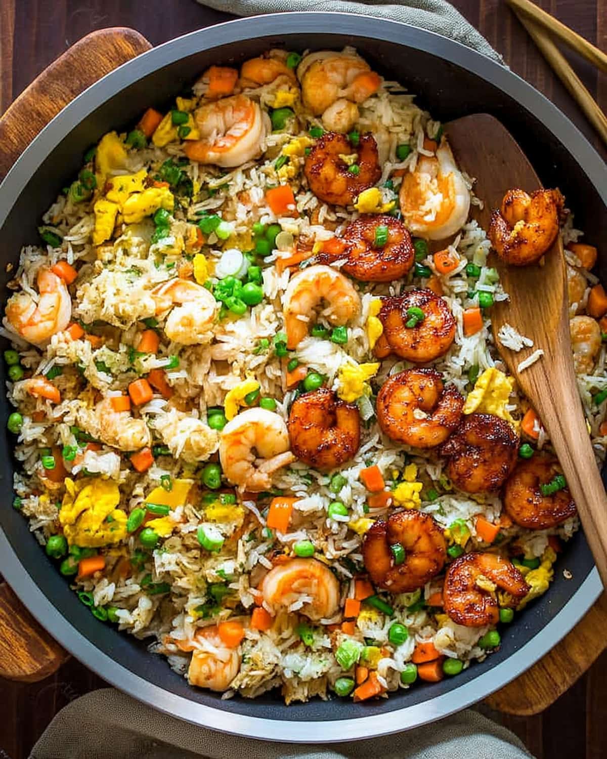 Shrimp fried rice meal prep with juicy shrimp, fluffy rice, scrambled eggs, peas, carrots, and green onions.