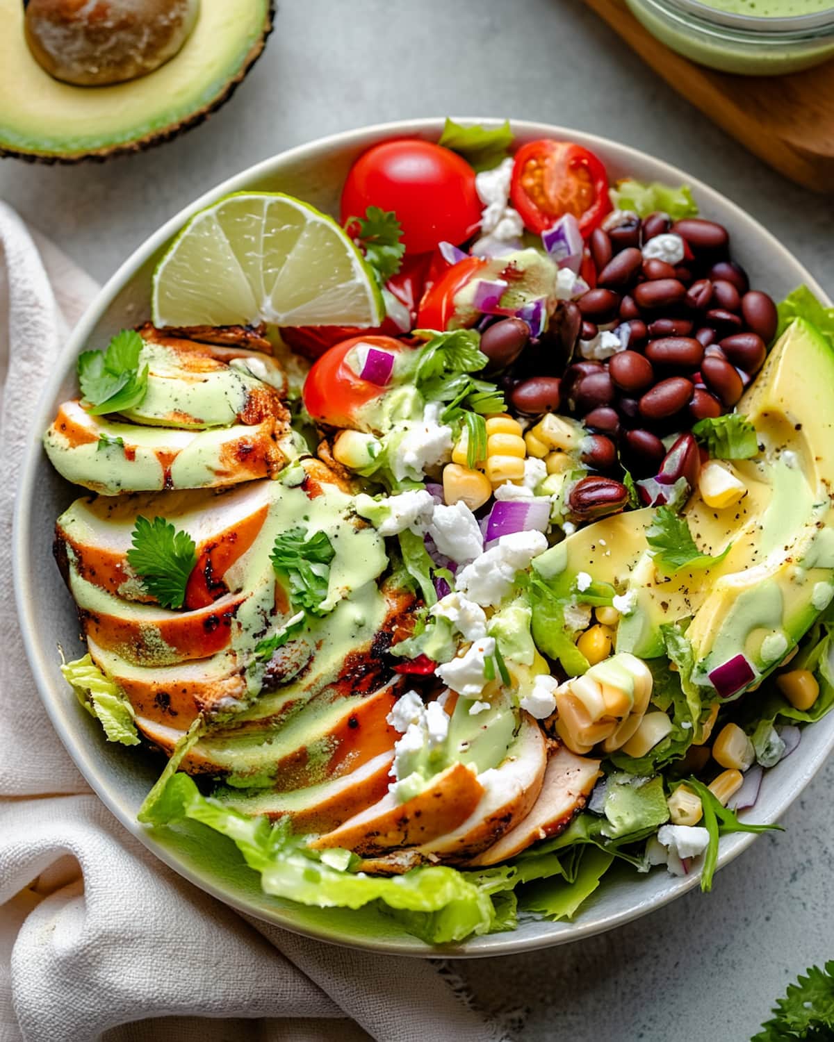 Southwest taco salad meal prep with grilled chicken, black beans, corn, avocado, cherry tomatoes.
